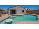 Backyard view of a refreshing pool featuring a step entry, seating table, and well-maintained brick border at 37053 W Amalfi Ave, Maricopa, AZ 85138