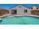 View of backyard with the kidney-bean-shaped pool, patio and house at 37053 W Amalfi Ave, Maricopa, AZ 85138