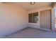 Enclosed front porch of a home with a window, beige walls, and a neutral-colored front door at 37053 W Amalfi Ave, Maricopa, AZ 85138