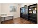 Cozy bedroom featuring a desk, dark wood floors, bright window, and shelving for storage and decor at 4032 S Santa Rita Pl, Chandler, AZ 85249