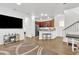 An open living space features a kitchen, hardwood flooring, a television, and a staircase at 4159 E Jasper Dr, Gilbert, AZ 85296
