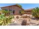 Exterior view of the backyard showing desert landscaping, including cacti and stone paths at 43875 W Baker Dr, Maricopa, AZ 85138