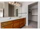 Bathroom featuring double sinks, oak cabinetry and a walk in closet at 43875 W Baker Dr, Maricopa, AZ 85138