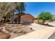 Charming single-story home with a two-car garage, desert landscaping, and a red tile roof at 43875 W Baker Dr, Maricopa, AZ 85138