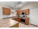 Well-equipped kitchen with stainless steel appliances, tile floors and wood cabinetry at 43875 W Baker Dr, Maricopa, AZ 85138