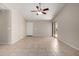 Open living room with tile flooring, bright natural light, ceiling fan, and access to the entry at 43875 W Baker Dr, Maricopa, AZ 85138