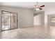 Open living room featuring tile flooring, sliding glass door, neutral paint, and a ceiling fan at 43875 W Baker Dr, Maricopa, AZ 85138