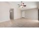Spacious living room with neutral paint, a ceiling fan, tile flooring, and bright natural light at 43875 W Baker Dr, Maricopa, AZ 85138