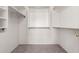 An empty walk-in closet with carpeted floors and a custom rod and shelf system for optimal organization at 43875 W Baker Dr, Maricopa, AZ 85138