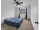 This bedroom features a ceiling fan and a bed, with a window view and neutral walls and carpet at 4416 E Riverside St, Phoenix, AZ 85040