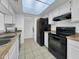 Modern kitchen boasts white cabinets, a black refrigerator, and updated appliances for seamless cooking at 4416 E Riverside St, Phoenix, AZ 85040