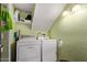 A compact laundry area with green painted walls, lighting, shelves, washer, and dryer at 4515 N 26Th Dr, Phoenix, AZ 85017
