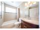 Well-lit bathroom features shower-tub combo and vanity with granite counters at 5249 E Shea Blvd # 215, Scottsdale, AZ 85254