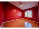 This bedroom is painted red and has hardwood floors and a ceiling fan at 5249 E Shea Blvd # 215, Scottsdale, AZ 85254