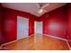 This bedroom is painted red and has hardwood floors and a ceiling fan at 5249 E Shea Blvd # 215, Scottsdale, AZ 85254