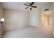 Spacious bedroom with neutral carpet, a ceiling fan and closet with sliding doors at 5249 E Shea Blvd # 215, Scottsdale, AZ 85254