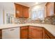 Bright kitchen features tile backsplash, stainless steel sink, and wood cabinets at 5249 E Shea Blvd # 215, Scottsdale, AZ 85254