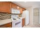 Bright kitchen features tile backsplash, stainless steel sink, and wood cabinets at 5249 E Shea Blvd # 215, Scottsdale, AZ 85254