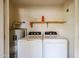 Inside laundry room with washer, dryer, hot water heater and utility shelf at 5249 E Shea Blvd # 215, Scottsdale, AZ 85254