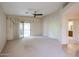Open-concept living room with neutral carpet, sliding glass doors and a ceiling fan at 5249 E Shea Blvd # 215, Scottsdale, AZ 85254