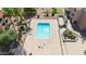 Drone shot of a pristine, turquoise swimming pool, lounging area, and shaded pergola within a well-kept community at 540 N May St # 1109, Mesa, AZ 85201