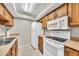 Well-lit kitchen featuring a double sink, white appliances, and wood cabinetry, offering functionality and style at 540 N May St # 1109, Mesa, AZ 85201