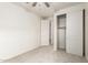 A carpeted bedroom showcases a ceiling fan, closet, and access to another room at 5626 W Rainwater Dr, Laveen, AZ 85339