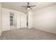 Spacious bedroom includes neutral carpet, a ceiling fan, a walk-in closet, and an ensuite bathroom at 5626 W Rainwater Dr, Laveen, AZ 85339