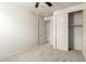 A carpeted bedroom showcases a ceiling fan, closet, and access to another room at 5626 W Rainwater Dr, Laveen, AZ 85339