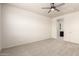 Clean bedroom with a ceiling fan, neutral carpet, and a doorway leading to an ensuite bathroom at 5626 W Rainwater Dr, Laveen, AZ 85339