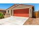 Close-up of a single-story home featuring a two-car garage, low maintenance landscaping, and a classic stucco facade at 5626 W Rainwater Dr, Laveen, AZ 85339