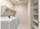 A clean laundry room features a washer, dryer, and storage shelves at 5626 W Rainwater Dr, Laveen, AZ 85339