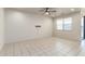 Spacious living room with neutral tile flooring, a ceiling fan, and access to the backyard at 5626 W Rainwater Dr, Laveen, AZ 85339