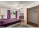 Cozy bedroom with a ceiling fan, purple curtains, and a vintage vanity with mirror at 62 W Beall Ave, Mesa, AZ 85210