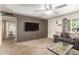 Inviting living room with gray accent wall, comfortable couch, ceiling fan, and access to other rooms at 62 W Beall Ave, Mesa, AZ 85210