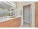 Bathroom with double sinks, wood cabinetry, and an adjoining toilet room at 705 W Queen Creek Rd # 1201, Chandler, AZ 85248