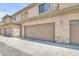 A view of the beige garage exterior, featuring stone accents and a well-maintained driveway at 705 W Queen Creek Rd # 1201, Chandler, AZ 85248