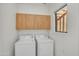 Well-lit laundry room with wood cabinets and a window for natural light at 705 W Queen Creek Rd # 1201, Chandler, AZ 85248
