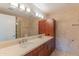 Bathroom with dual sinks, travertine tile, and wood cabinetry at 7167 E Rancho Vista Dr # 2007, Scottsdale, AZ 85251