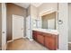 Bathroom with double sinks, dark wood cabinetry, and neutral tile flooring at 8417 W Northview Ave, Glendale, AZ 85305