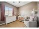 Bedroom with crib, dresser, chair, and cactus wall decor at 8417 W Northview Ave, Glendale, AZ 85305