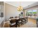 Elegant dining room with a spacious table, stylish chandelier, and a large window offering outdoor views at 8417 W Northview Ave, Glendale, AZ 85305