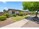 Landscaped front yard featuring lush grass, palm trees, and decorative stone accents at 8417 W Northview Ave, Glendale, AZ 85305
