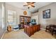 Well-lit home office with a large desk, built-in bookcase, and comfortable seating for a productive workspace at 8417 W Northview Ave, Glendale, AZ 85305