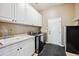 Laundry room with white cabinets, front loading washer and dryer, utility sink at 8417 W Northview Ave, Glendale, AZ 85305