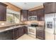Bright kitchen featuring stainless steel appliances, dark cabinetry, stone countertops and neutral tile flooring at 865 E Del Rio St, Chandler, AZ 85225