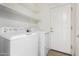 Clean laundry room equipped with a washer and dryer, and storage shelves above at 865 E Del Rio St, Chandler, AZ 85225