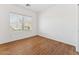 Third bedroom featuring wood floors, a large window, and a closet at 8758 W Myrtle Ave, Glendale, AZ 85305
