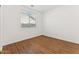 Second bedroom featuring wood floors, a large window, and a closet at 8758 W Myrtle Ave, Glendale, AZ 85305