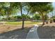 Scenic pathway leading to community park featuring mature trees, walking trails, and recreational facilities at 8758 W Myrtle Ave, Glendale, AZ 85305